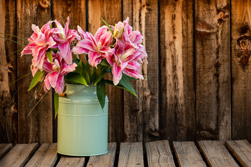 Bouquet of lilies in a green container with room for copy