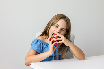 Criança saboreia maça deliciosa com expressões de satisfação