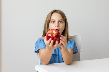 Criança saboreia maça deliciosa com expressões de satisfação