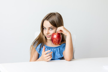 Criança saboreia maça deliciosa com expressões de satisfação