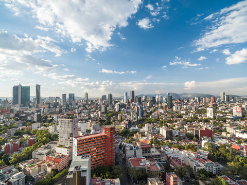 Vista a&eacute;rea panor&aacute;mica de la Ciudad de M&eacute;xico sobre la Colonia Roma con vista al norte y un cielo azul como fondo.