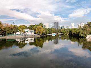 Fototapeta na wymiar Vista aérea sobre el lago artificial de la primera sección del Bosque de Chapultepec con el skyline de Polanco reflejado sobre el lago.