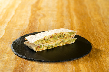 Quesadilla sobre tabla de pizarra negra y madera