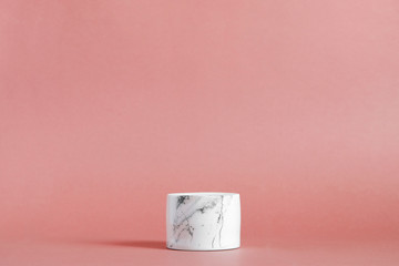 Empty white marble podium on pastel pink color background. Minimal boxes and geometric podium. Scene with geometrical forms. Empty showcase for cosmetic product presentation. Fashion magazine.