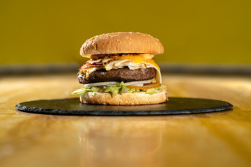 Hamburguesa sobre tabla de pizarra y madera