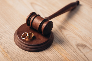 selective focus of golden rings on wooden gavel, divorce concept