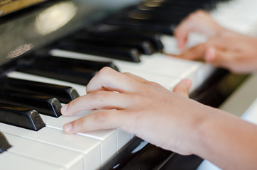 Obraz premium manos tocando piano, manos de joven tocando piano