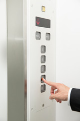 エレベーターのボタンを押す手元