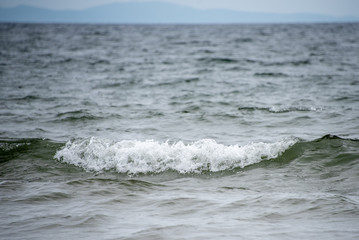 Small waves on the sea coast, foaming waves