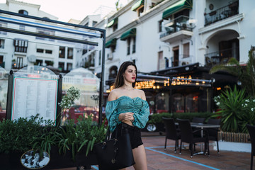Chica joven posando delante de un edificio blanco en malaga