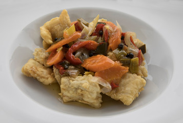 Gourmet food. Fish with marinade sauce. Closeup of pickled breaded and fried hake with vegetables.