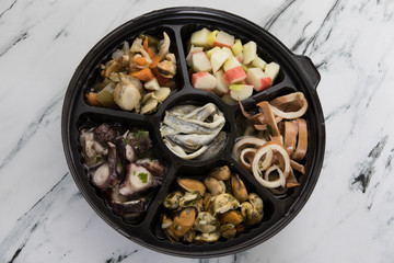 Traditional mediterranean seafood picada dish with a variety of seafood preparations. Squid, mussels and octopus with provencal condiment. Anchovies, scallops and pickles in vinegar. Kanikama salad.