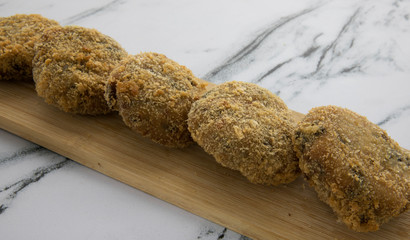 Gourmet. Rustic dish presentation. Fried crispy crab croquettes in a wooden tablet on the table.	
