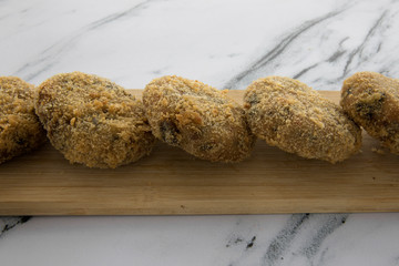 Gastronomy. Seafood. Deep fried crab croquettes in a wooden tablet.