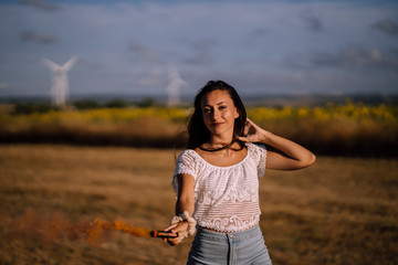Chica feliz en campo con bomba de humo