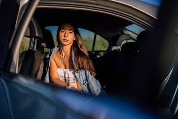 Obraz na płótnie Canvas Retratos de una chica joven y guapa en un coche