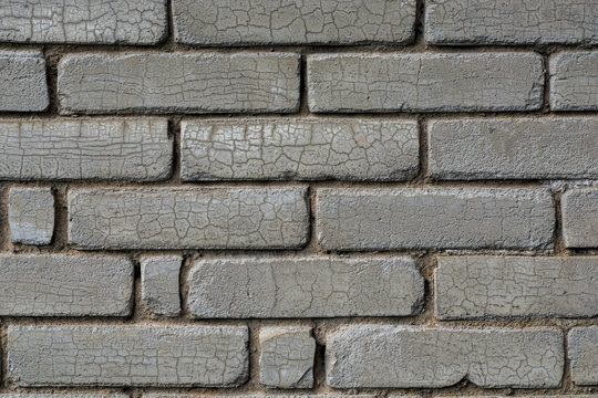 Fototapeta Gray brick wall background. The texture of the old brick wall is horizontal. Cracks form a beautiful mesh