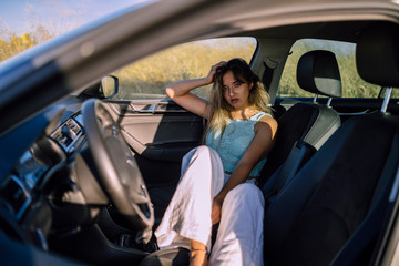 Fototapeta na wymiar Retratos de una chica joven y guapa en un coche