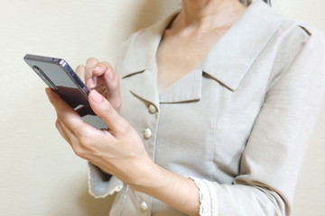 スマホを操作するスーツ姿の女性