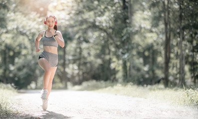 Young beautiful asian woman in sportswear and headset running outdoors in the park with happiness.