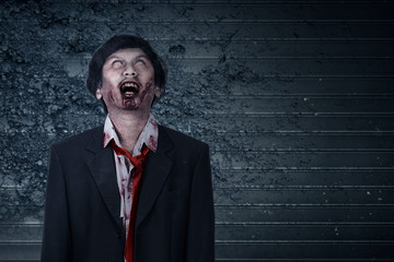 Scary zombie with blood and wound on his body standing