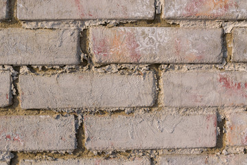 Red brick wall for the backdrop. The surface of the wall is covered with old white paint. Gray cement joints.
