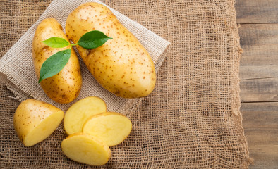 fresh potato on wood background, organic food
