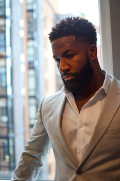 Handsome African American Business Man in Suit Stands Next to Window