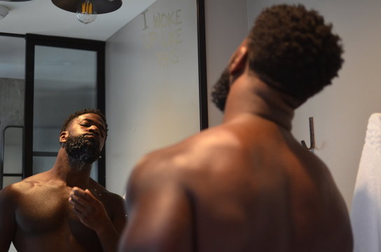 African American man looks at himself in the mirror