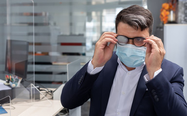 business man with glasses embarrassed because of the surgical mask