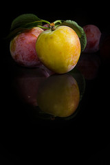 Ripe plums on a black background