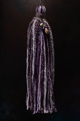 Borla colgante cortina color crudo de cintas de hilo de lana y piedras y joyas con fondo negro