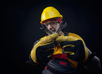 a guy in overalls and a construction helmet with a wrench