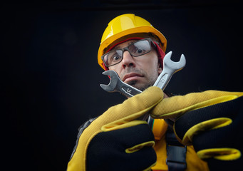 Fototapeta premium a guy in overalls and a construction helmet with a wrench