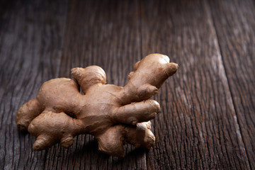 selective focus of ginger root on wooden background 