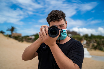 Chico joven haciendo fotos por la playa