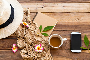 notebook ,mobile phone ,hot coffee ,knitting yarn and frangipani  of lifestyle woman relax summer arrangement flat lay style on background  wooden 