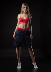 athletic girl in Boxing shorts on a black background