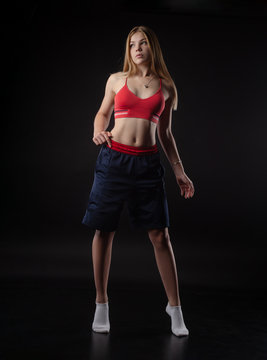 athletic girl in Boxing shorts on a black background
