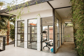 Private gym at home. Small gym in Luxury villa, big window, tropical view with palm trees skyline