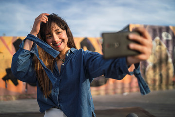 Chica joven en un skate park haciendose selfies