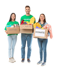 Volunteers with donations for orphans on white background