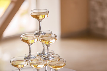 Tower made of glasses with champagne indoors