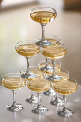 Tower made of glasses with champagne on table