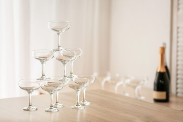 Tower made of empty glasses on table in room
