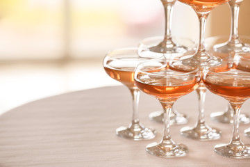 Tower made of glasses with champagne on table