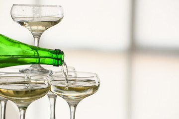 Pouring of tasty champagne from bottle into glass, closeup