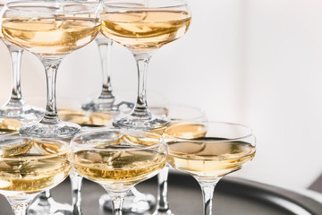 Tower made of glasses with champagne on table, closeup