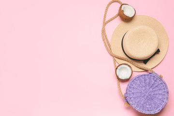 Straw hat and bag on color background