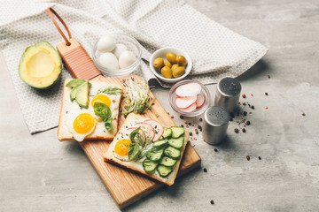 Board with tasty avocado sandwiches on table